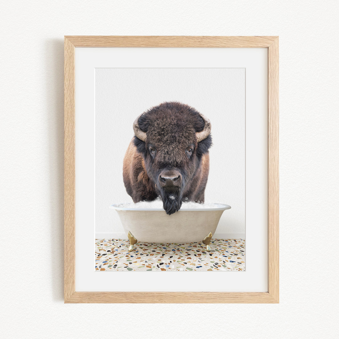 A buffalo with large horns is standing in a white bathtub filled with water, creating a playful and whimsical scene.