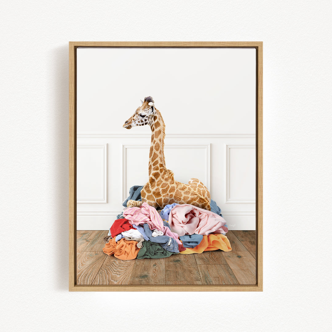 A giraffe standing on a pile of clothes in a room.