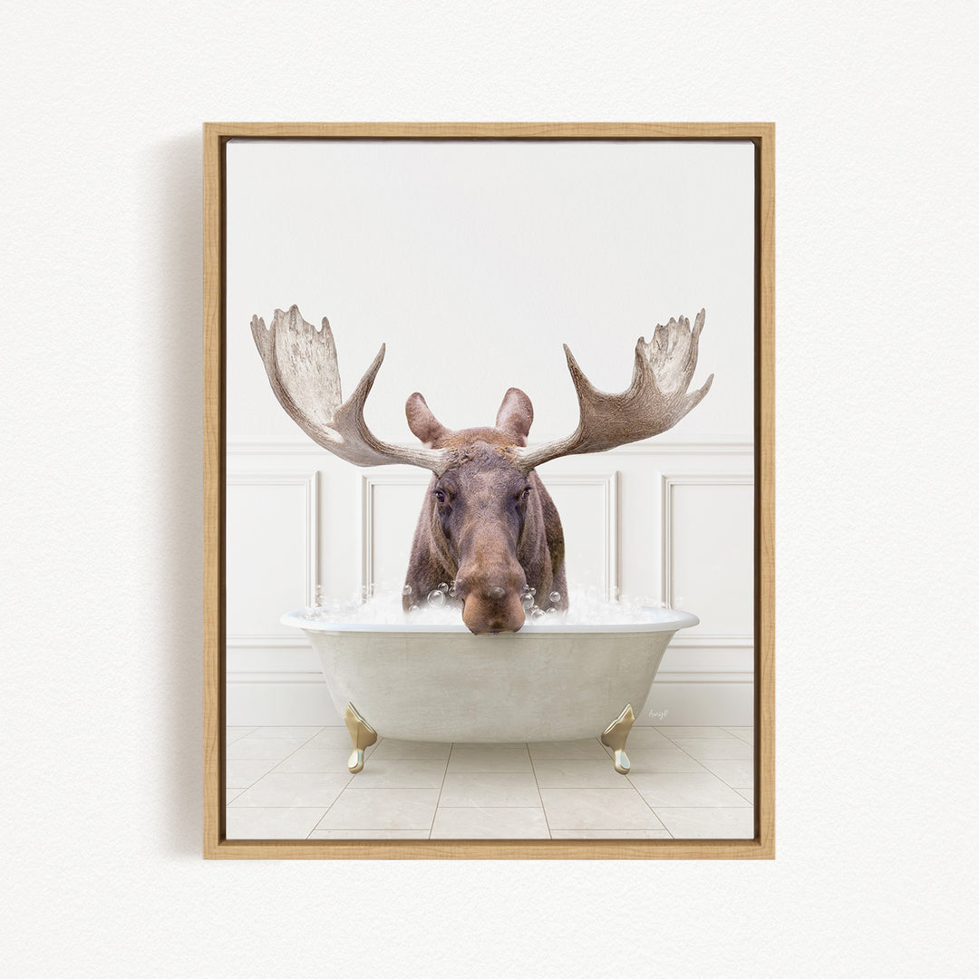 A moose with large antlers is sitting in a bathtub filled with water, creating a whimsical and humorous scene.