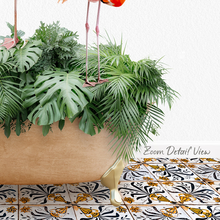 A large potted plant with lush green leaves sits on a patterned tile floor, with a pair of pink flamingos standing on the plant's legs.