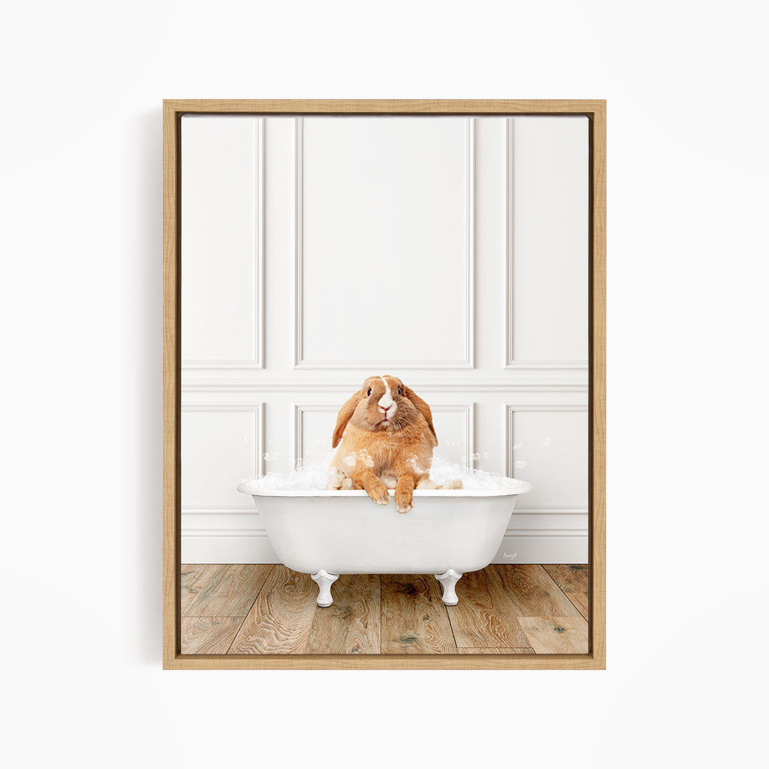 A brown rabbit sitting in a white bathtub filled with bubbles, looking directly at the camera.