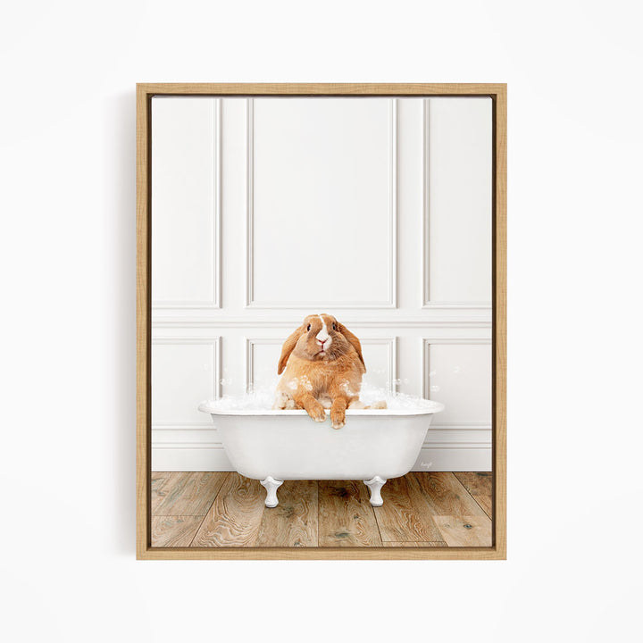 A brown rabbit sitting in a white bathtub filled with bubbles, looking directly at the camera.