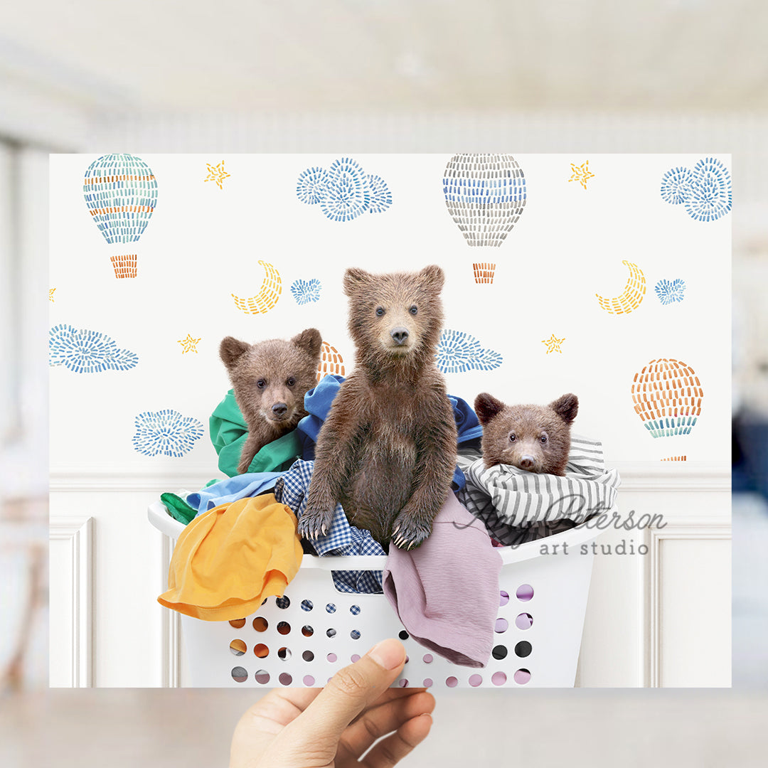 a person holding a picture of three bears in a laundry basket