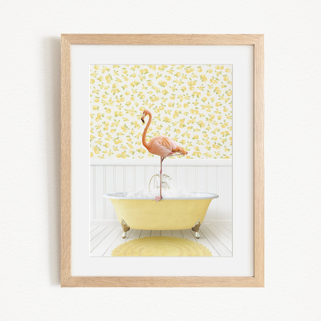 A framed image depicting a pink flamingo standing on the edge of a yellow bathtub filled with water, set against a yellow and white floral wallpaper.