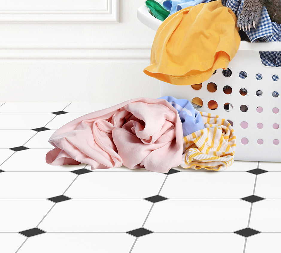 a pile of clothes sitting on top of a tiled floor