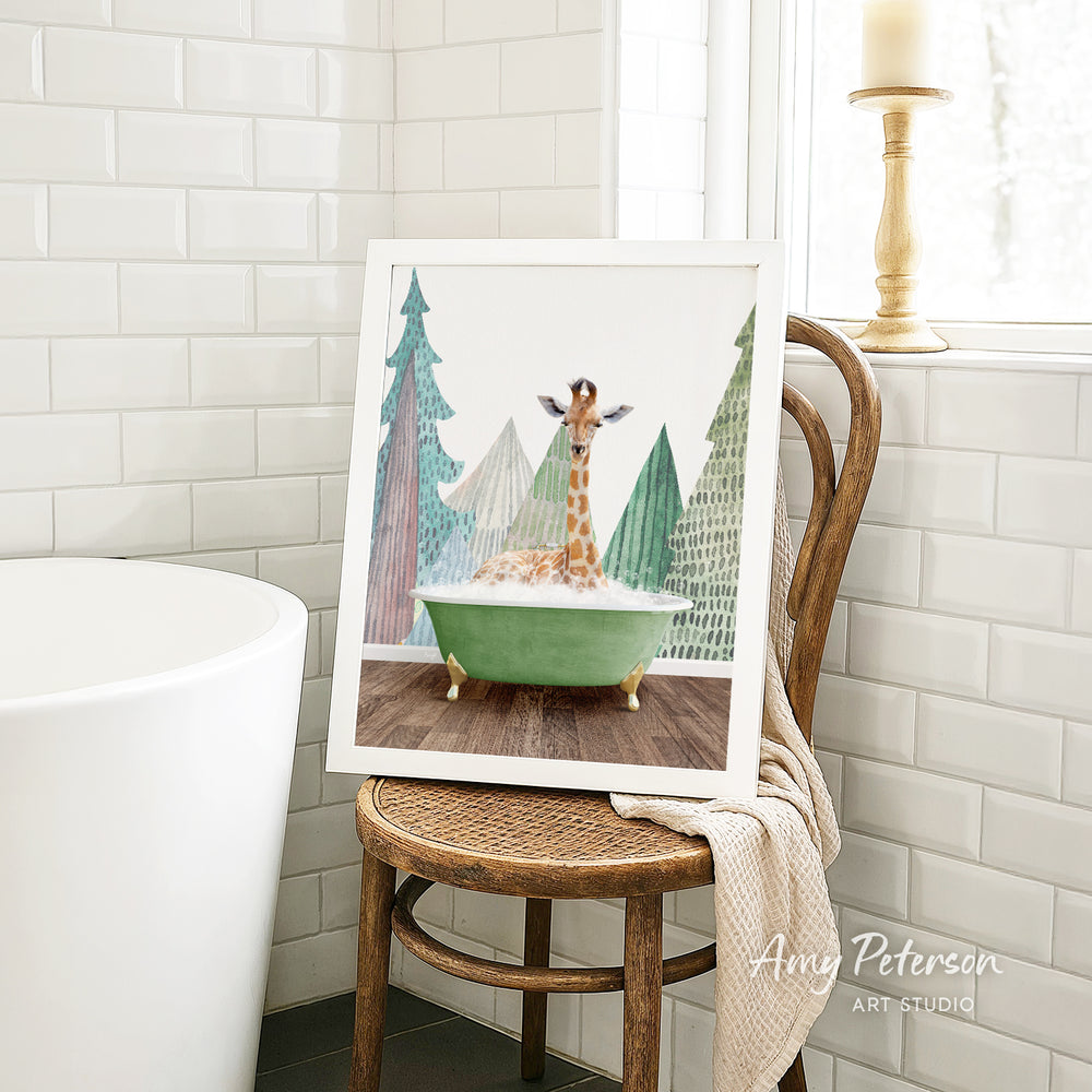 A framed painting of a giraffe sitting in a green bathtub, surrounded by trees, is displayed on a wooden chair in a bathroom setting.