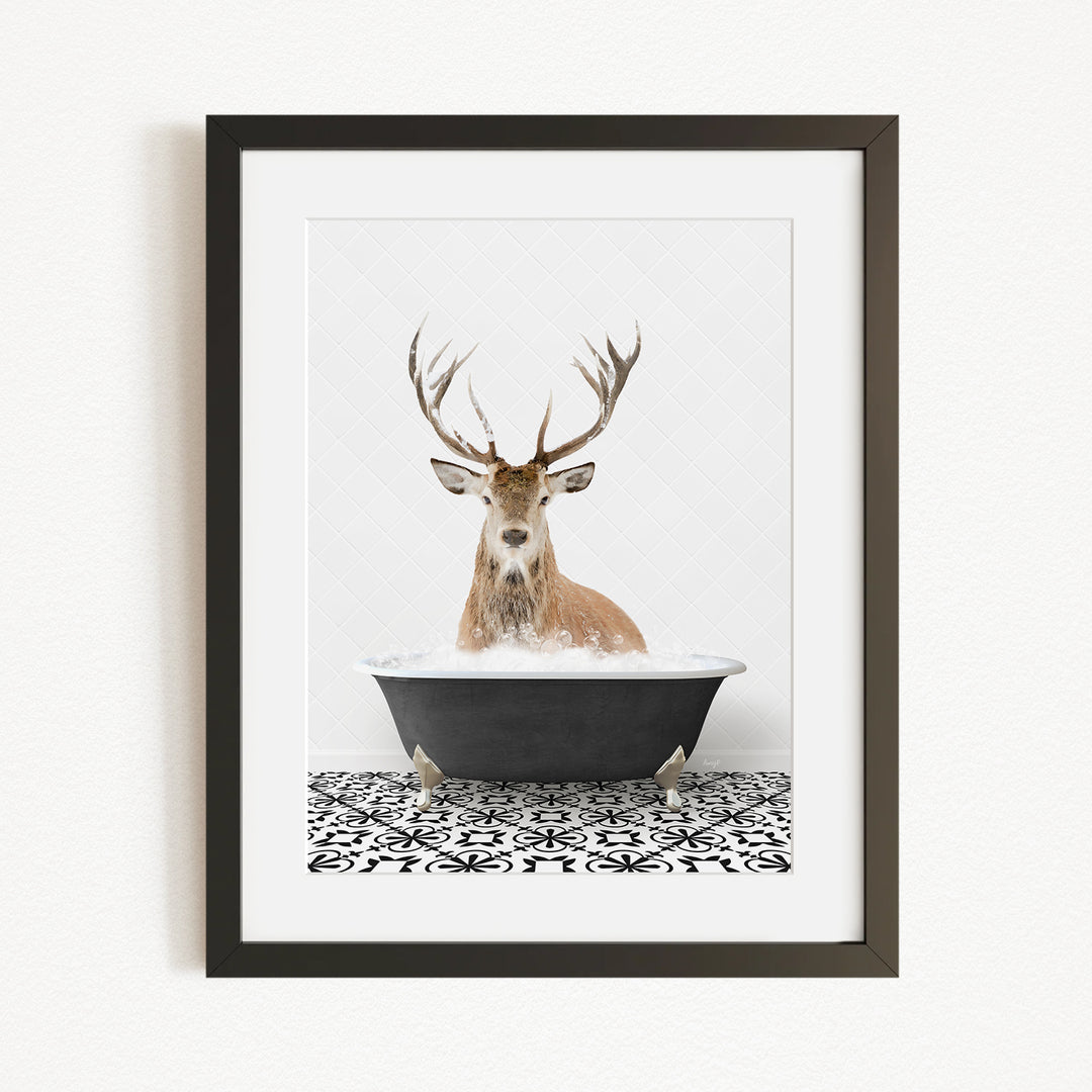 A deer with large antlers is sitting in a black bathtub filled with water, creating a whimsical and unexpected scene.
