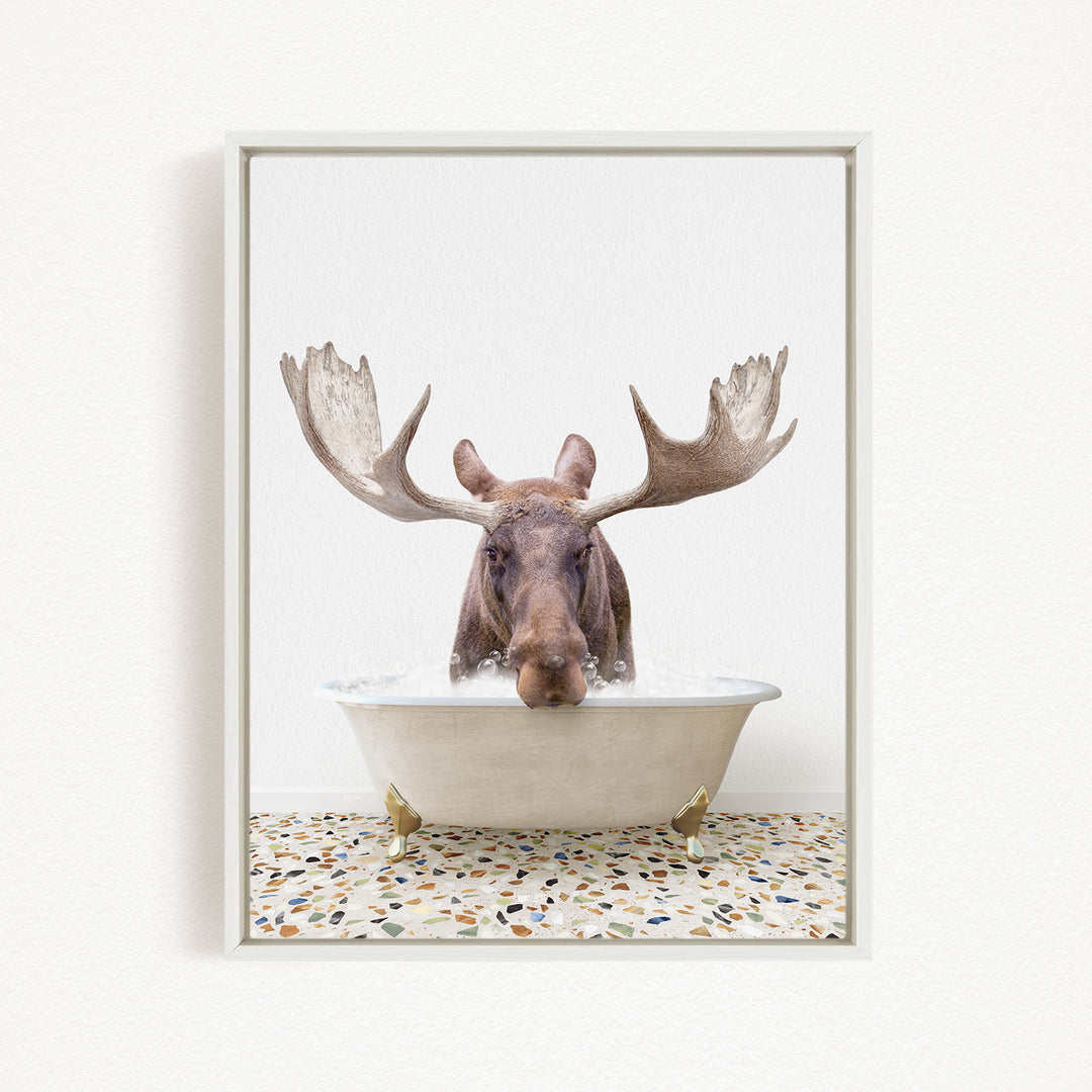A moose with large antlers is sitting in a bathtub filled with water, creating a whimsical and humorous scene.