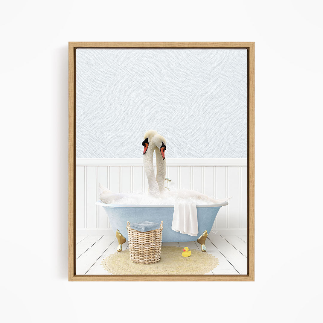 A pair of swans sitting in a blue bathtub filled with bubbles, surrounded by a basket of toys and a yellow rubber duck.