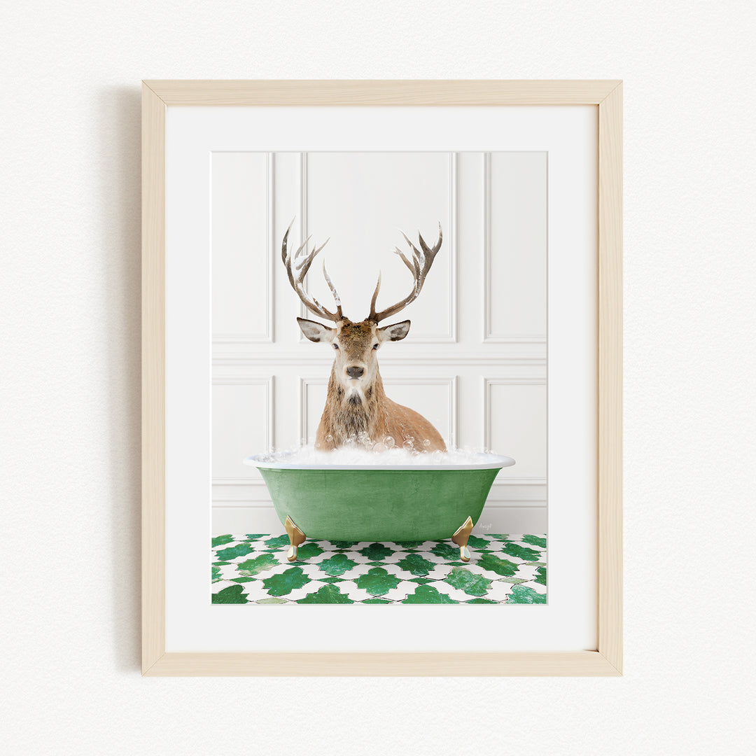 A deer with antlers is sitting in a green bathtub filled with water, surrounded by a green and white patterned rug.