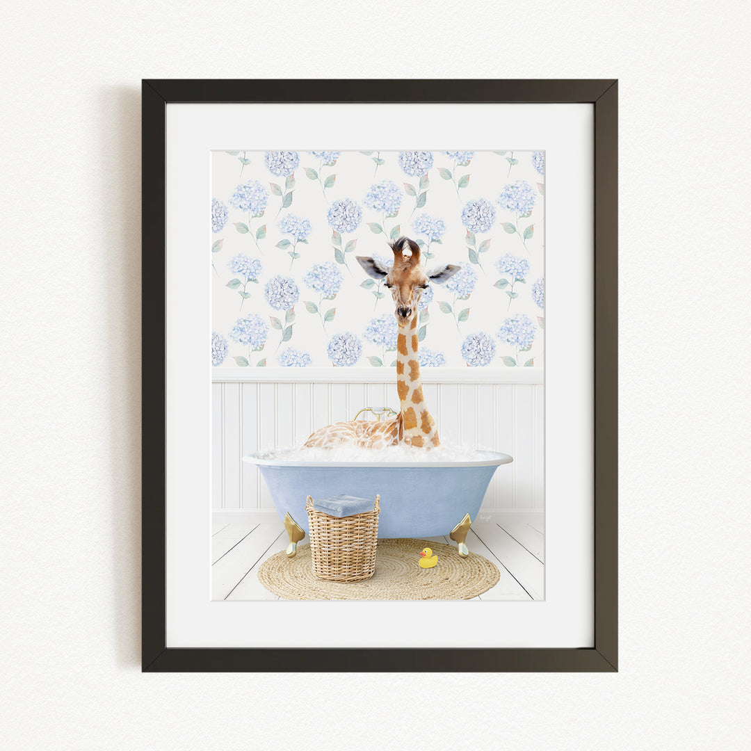 A giraffe sitting in a blue bathtub filled with bubbles, surrounded by a wicker basket and yellow rubber ducks.