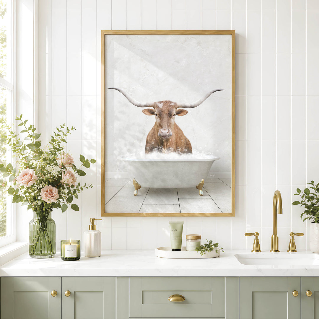 a bathroom with a framed picture of a bull with long horns sitting in a bathtub, surrounded by flowers and candles.