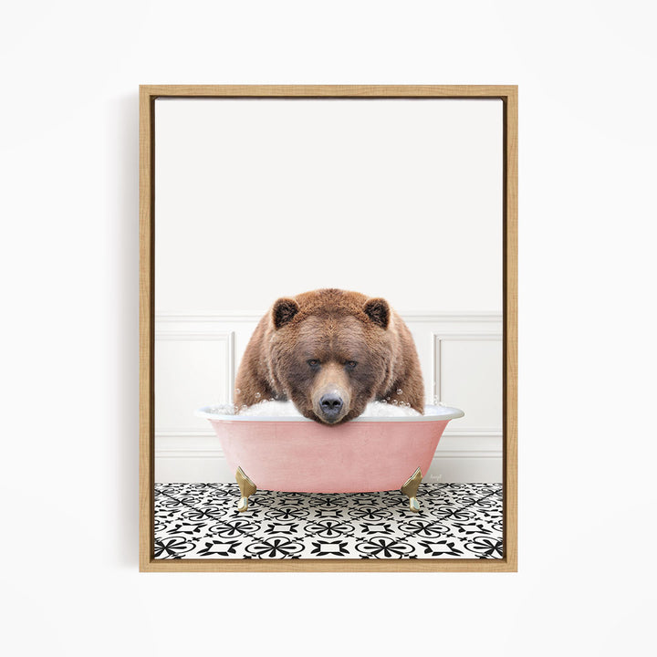 A brown bear is sitting in a pink bathtub, appearing to be enjoying a bath.