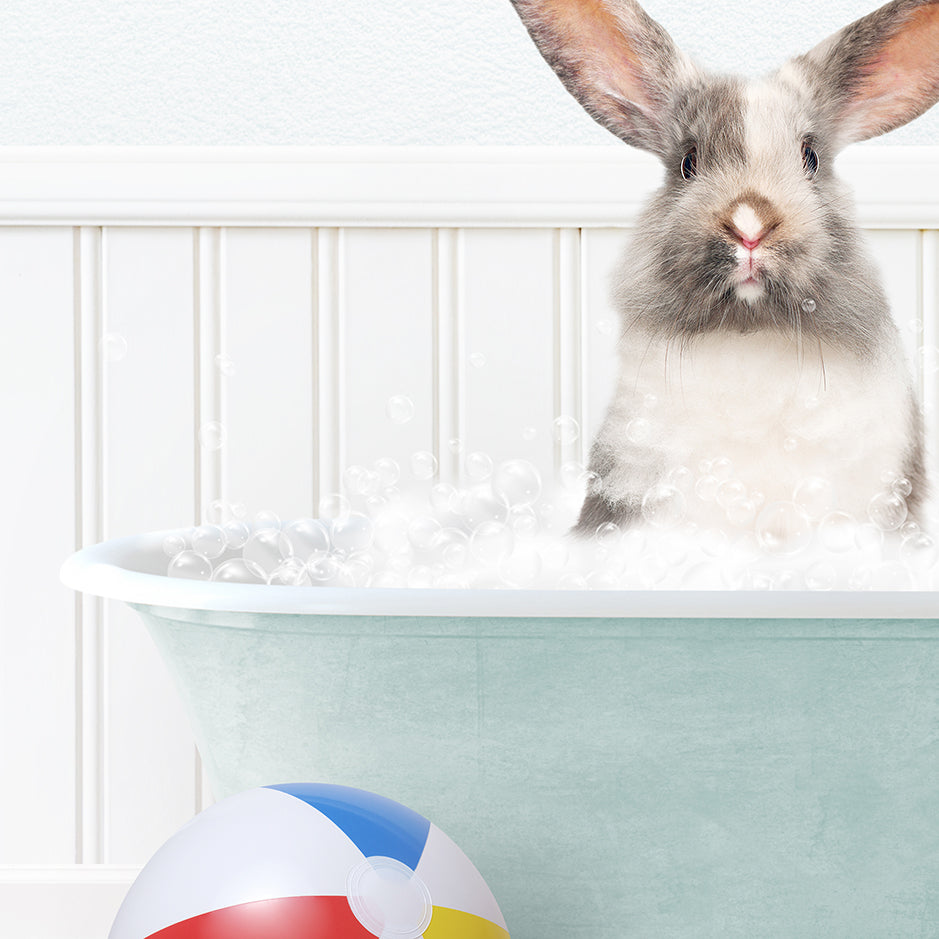 a bunny in a bathtub with bubbles and a beach ball