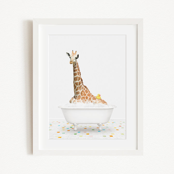 A giraffe sitting in a white bathtub filled with bubbles, with a yellow rubber duck floating on the water.