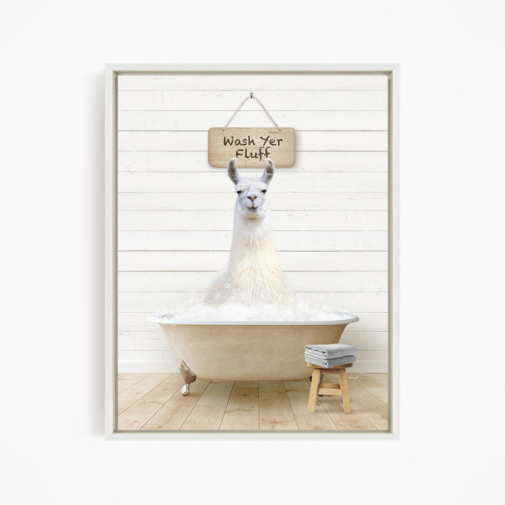 A white llama sitting in a bathtub, with a wooden sign above it that says "Wash Yer Fluff".