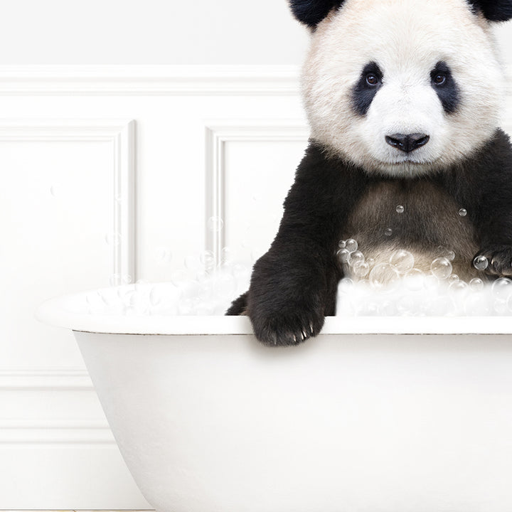 a black and white panda bear sitting in a bathtub