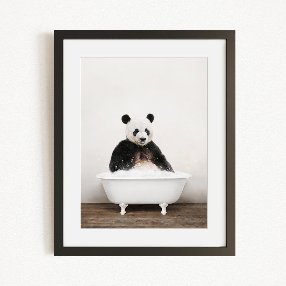 A panda bear sitting in a white bathtub filled with bubbles, looking directly at the camera.