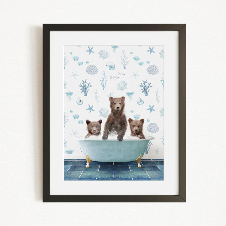 A framed image depicting three brown bears sitting in a bathtub filled with water, surrounded by a blue and white ocean-themed wallpaper.