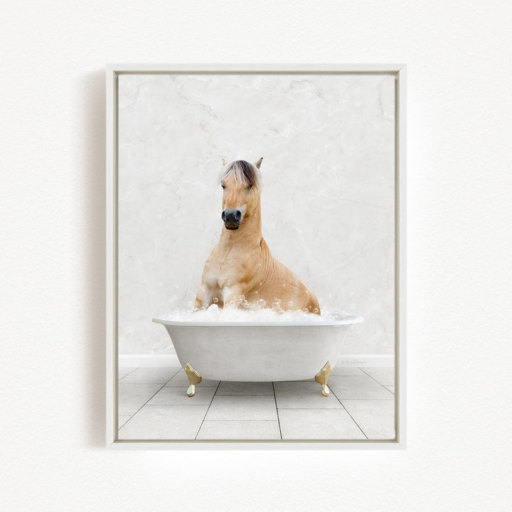 A light brown horse is sitting in a white bathtub filled with bubbles, creating a whimsical and playful scene.
