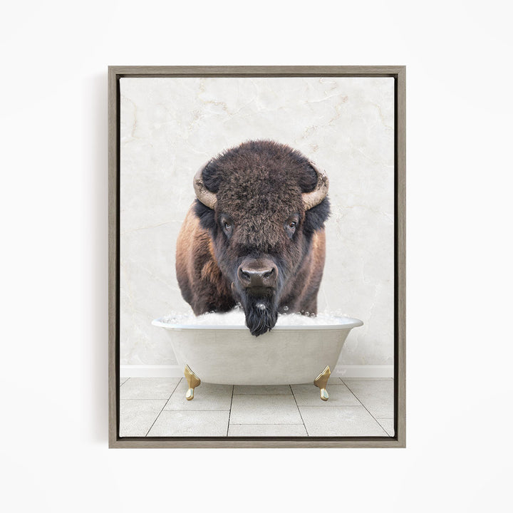 A buffalo with large horns is standing in a white bathtub, appearing to be enjoying a bath.