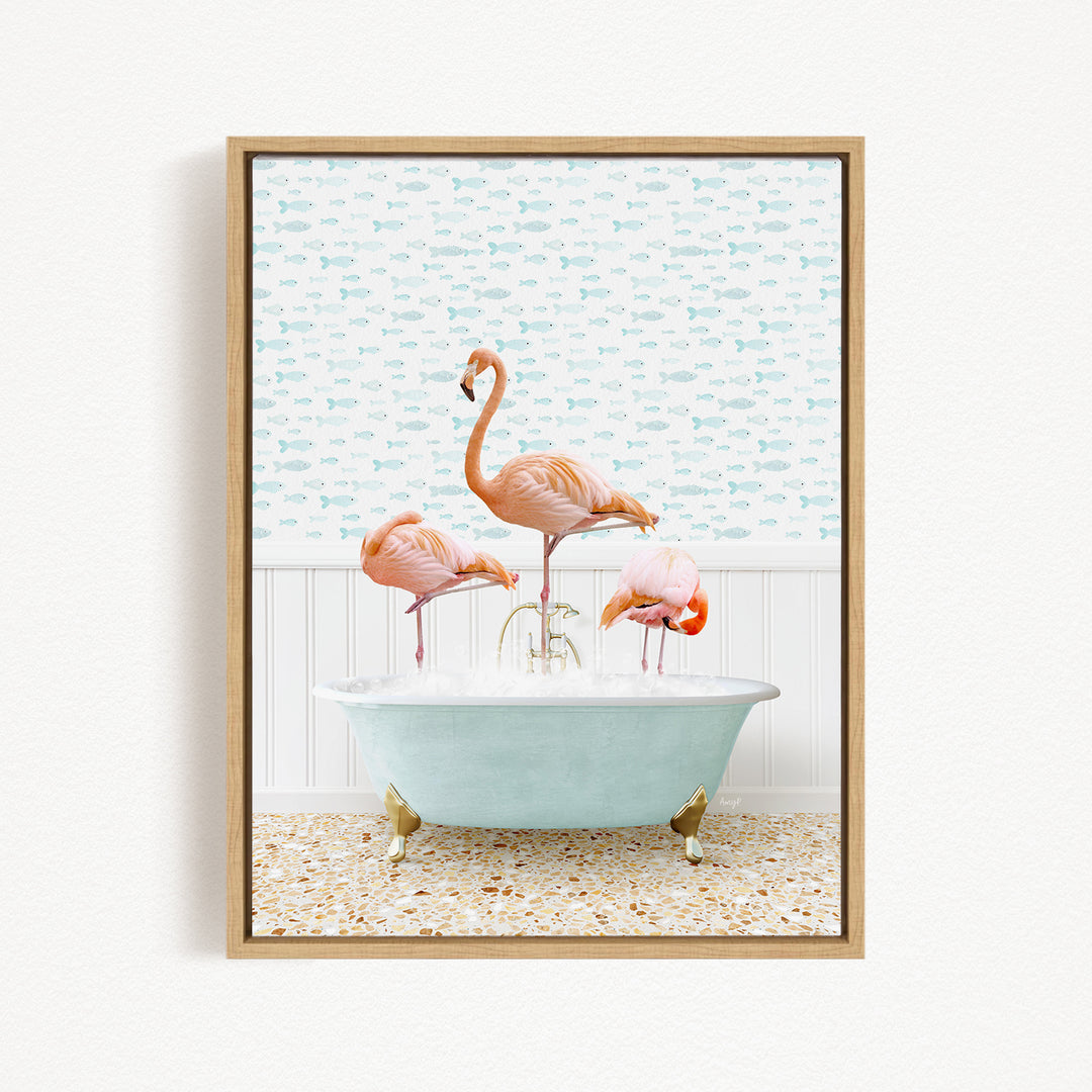 A framed image depicting three pink flamingos standing in a bathtub filled with water, with a patterned wallpaper in the background.