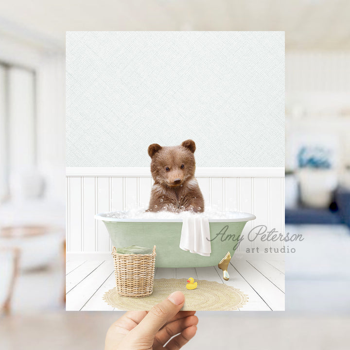 a person holding up a picture of a teddy bear in a bathtub