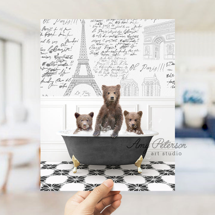 a person holding up a card with three bears in a bathtub