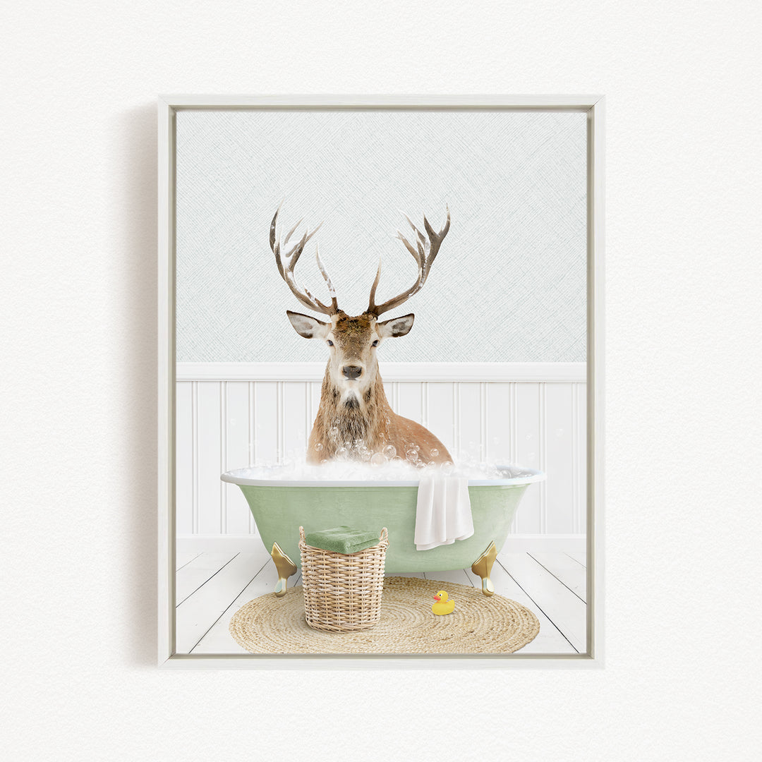A deer with antlers is sitting in a green bathtub filled with bubbles, surrounded by a basket of toys and a yellow rubber duck.