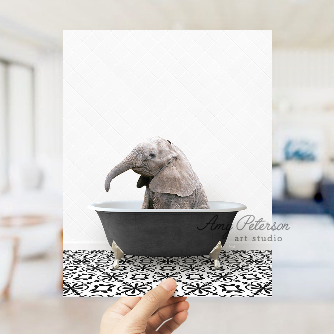 a person holding up a picture of an elephant in a bathtub