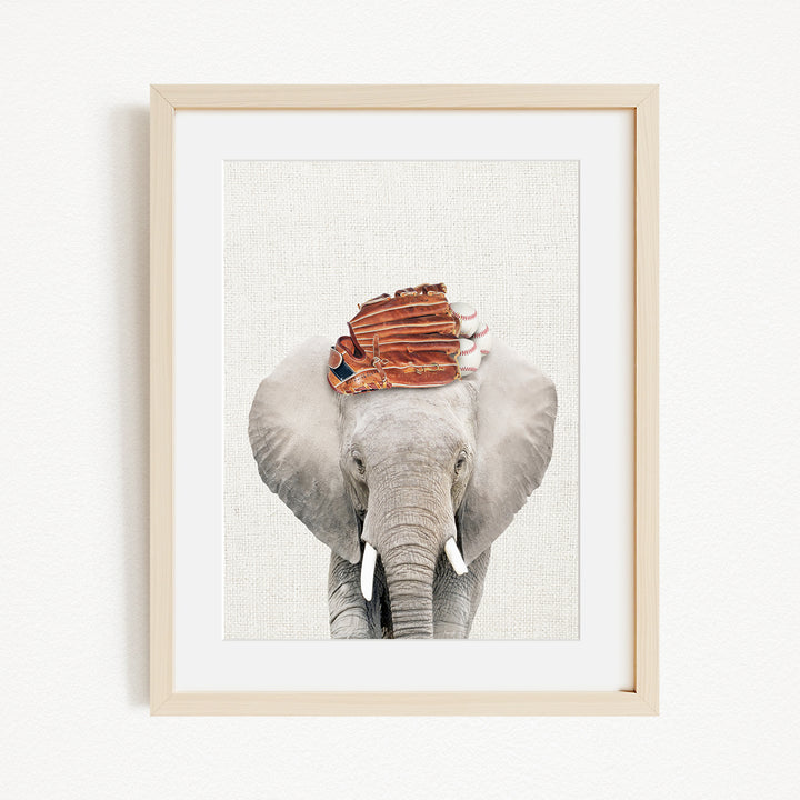 A framed photograph of an elephant wearing a baseball cap.