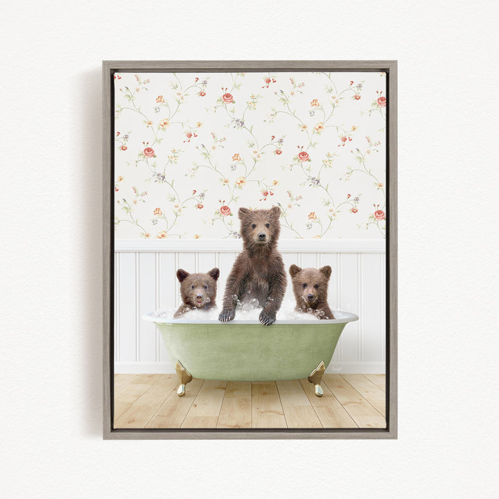 A framed image depicting three bears sitting in a green bathtub, with a floral wallpaper in the background.