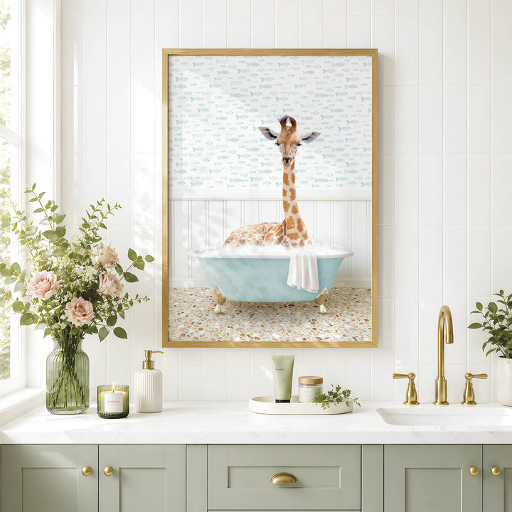 A giraffe sitting in a blue bathtub, surrounded by flowers and a framed picture, in a bathroom setting with a white countertop and gold fixtures.