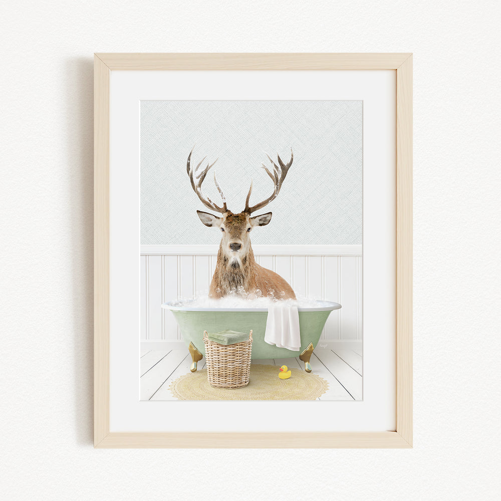A deer with antlers is sitting in a green bathtub filled with bubbles, surrounded by a basket of rubber ducks and a yellow rubber ducky.