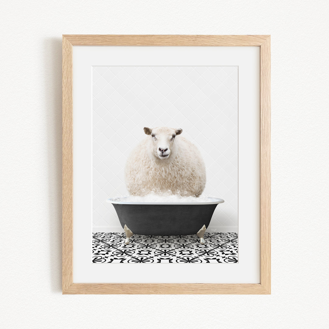 A fluffy white sheep sits in a black bathtub filled with bubbles, creating a whimsical and playful scene.