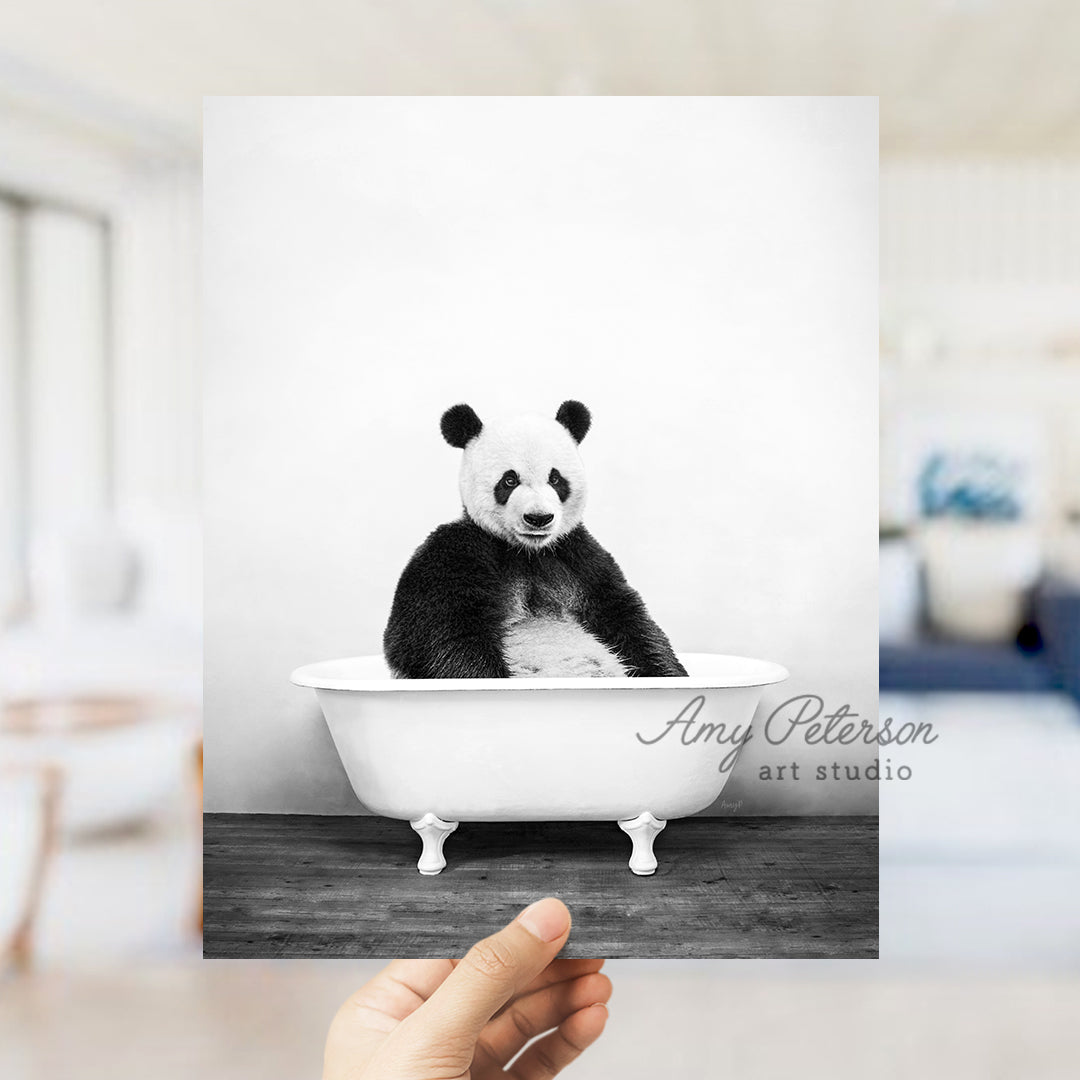 a black and white photo of a panda bear in a bathtub