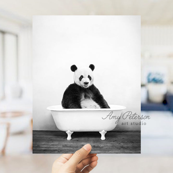 a black and white photo of a panda bear in a bathtub