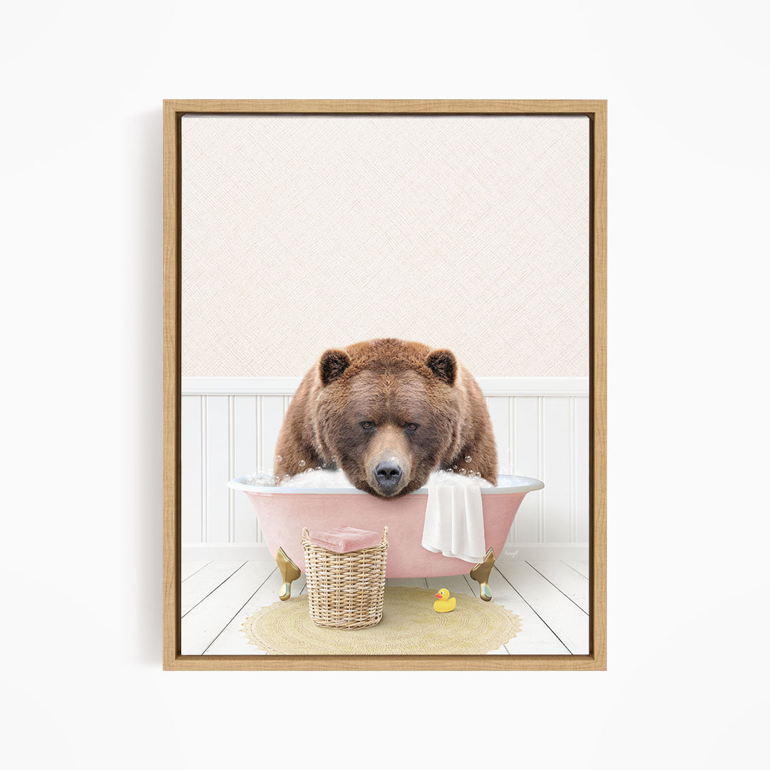 A brown bear is sitting in a pink bathtub filled with water, surrounded by a yellow rubber duck and a white towel.