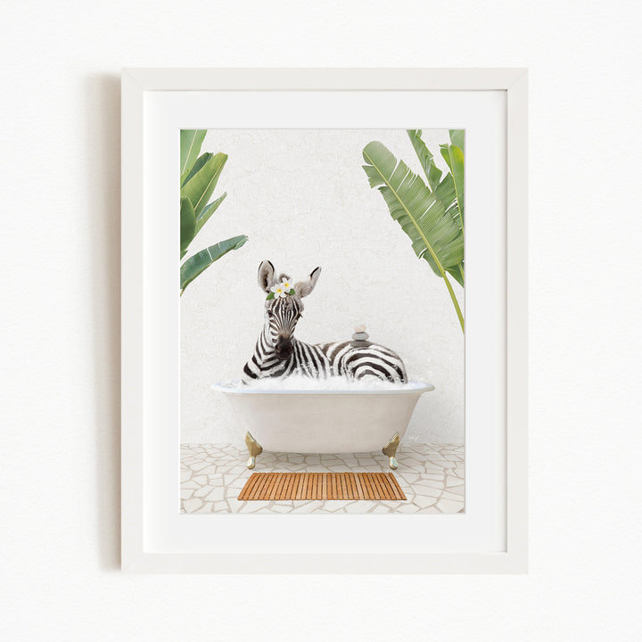 A zebra is sitting in a white bathtub, surrounded by green leaves, creating a whimsical and playful scene.