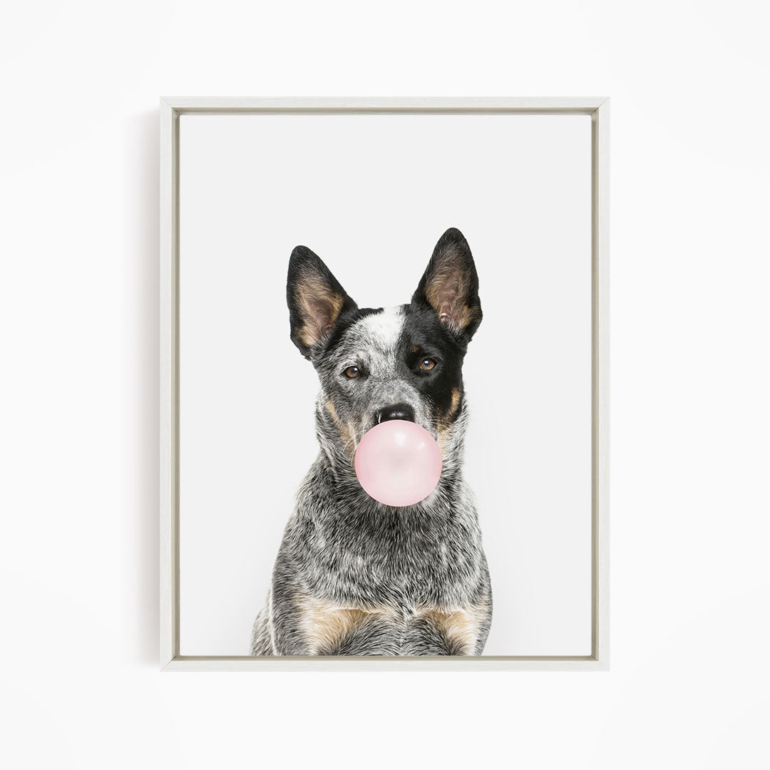 A black and white dog is blowing a pink bubble with its mouth, creating a playful and whimsical scene.