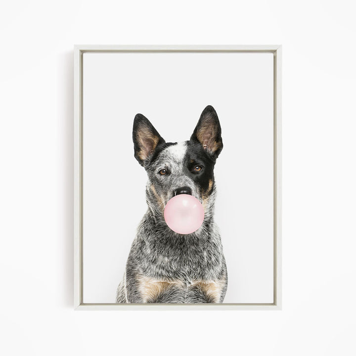A black and white dog is blowing a pink bubble with its mouth, creating a playful and whimsical scene.