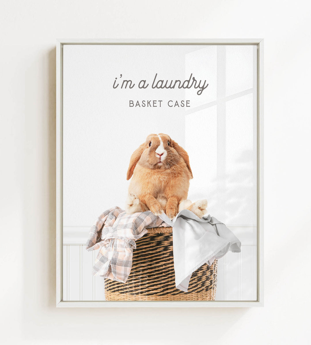 A picture of a rabbit sitting in a basket filled with clothes, accompanied by the text "I'm a laundry Basket Case".