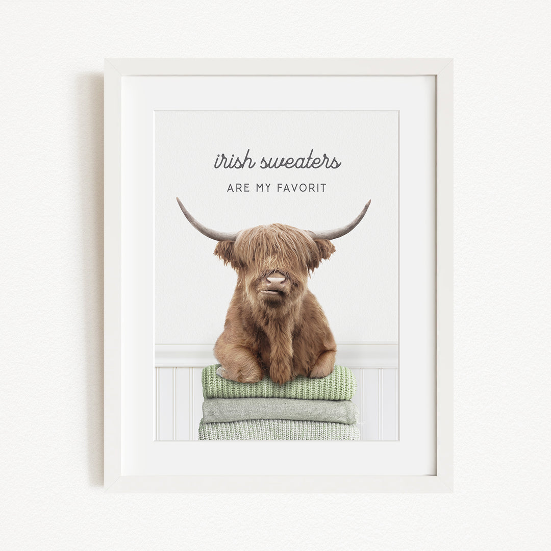 a brown cow with long horns sitting on a stack of green towels.