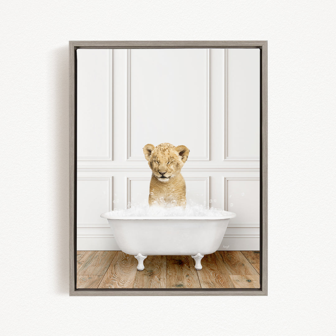 A young lion cub sitting in a white bathtub filled with water, looking up at the camera.