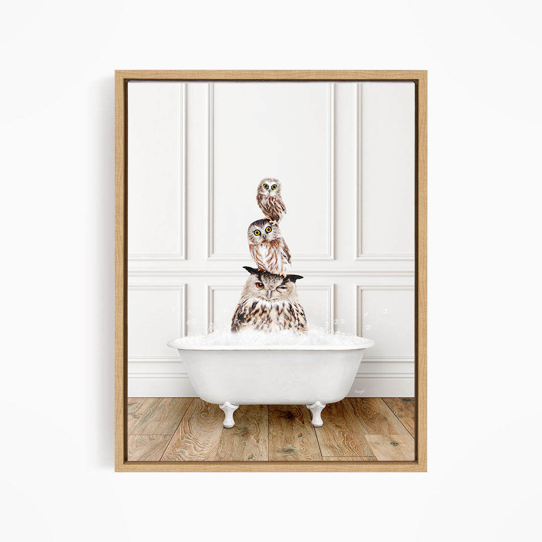 A framed image depicting three owls sitting in a white bathtub, with the top owl perched on the rim of the tub.