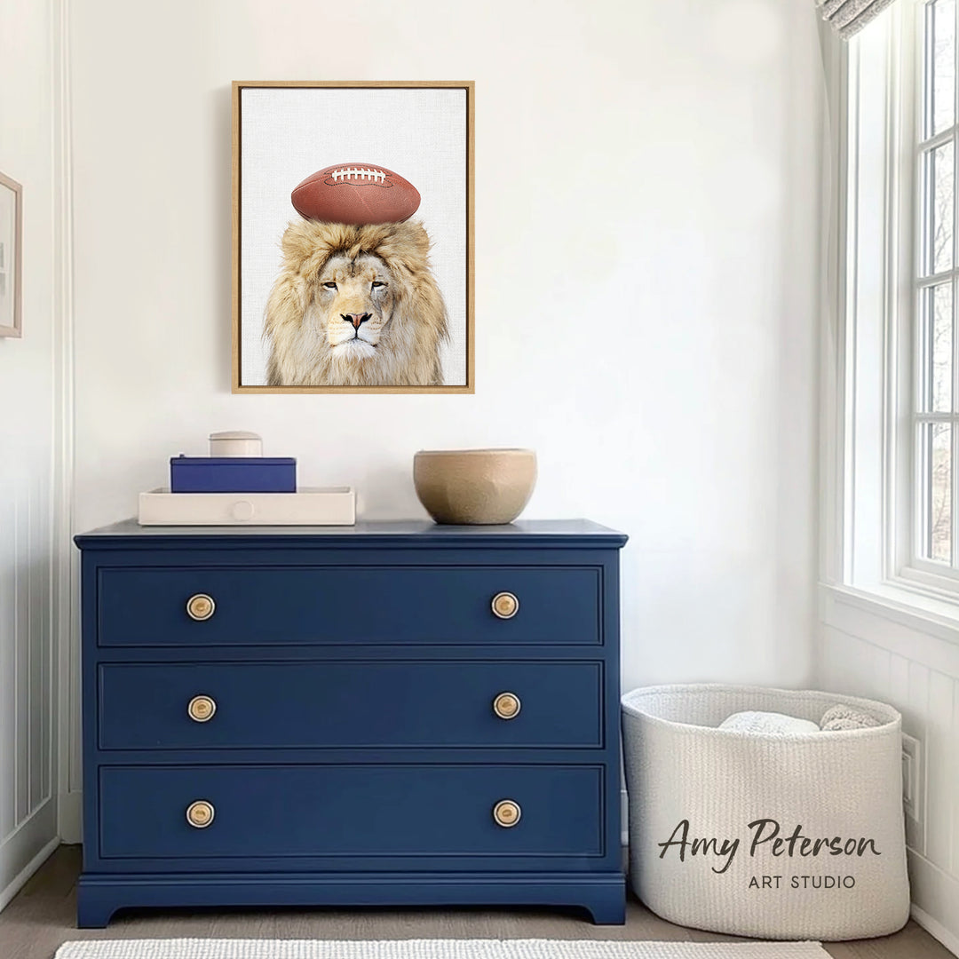 a blue dresser with a framed picture of a lion wearing a football helmet on top of it. The dresser is situated in a room with a window and a white basket.