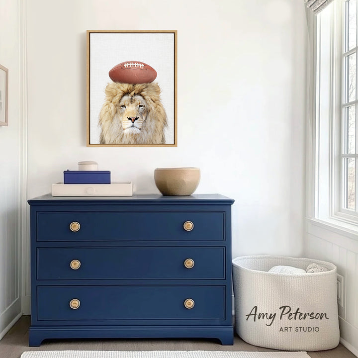 a blue dresser with a framed picture of a lion wearing a football helmet on top of it. The dresser is situated in a room with a window and a white basket.