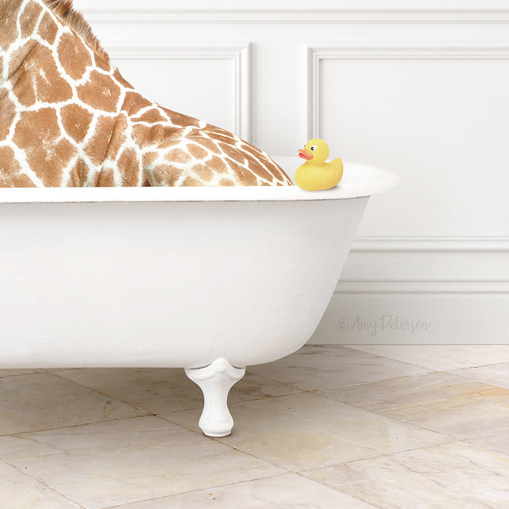 A giraffe is sitting in a white bathtub, with a yellow rubber duck resting on the edge of the tub.