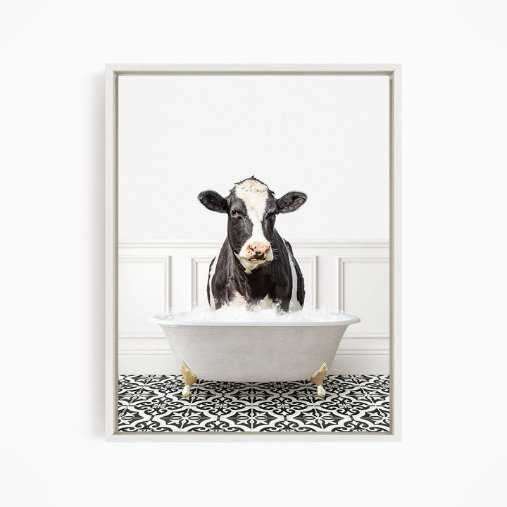 A black and white cow standing in a white bathtub filled with water, creating a whimsical and humorous scene.