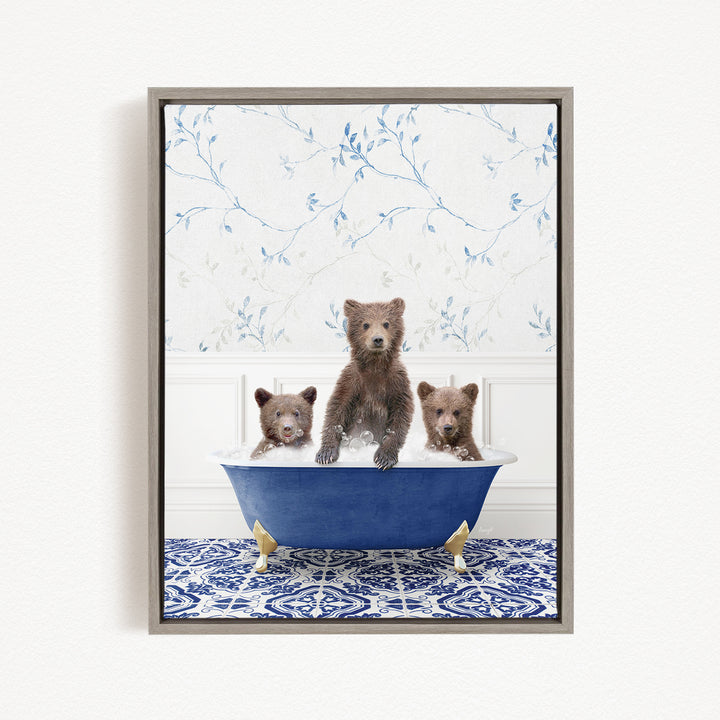 A framed image depicting three bears sitting in a blue bathtub, with a floral patterned wall behind them.